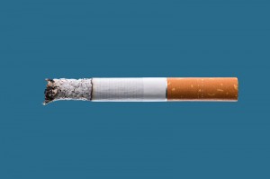 Cigarette burning on blue background